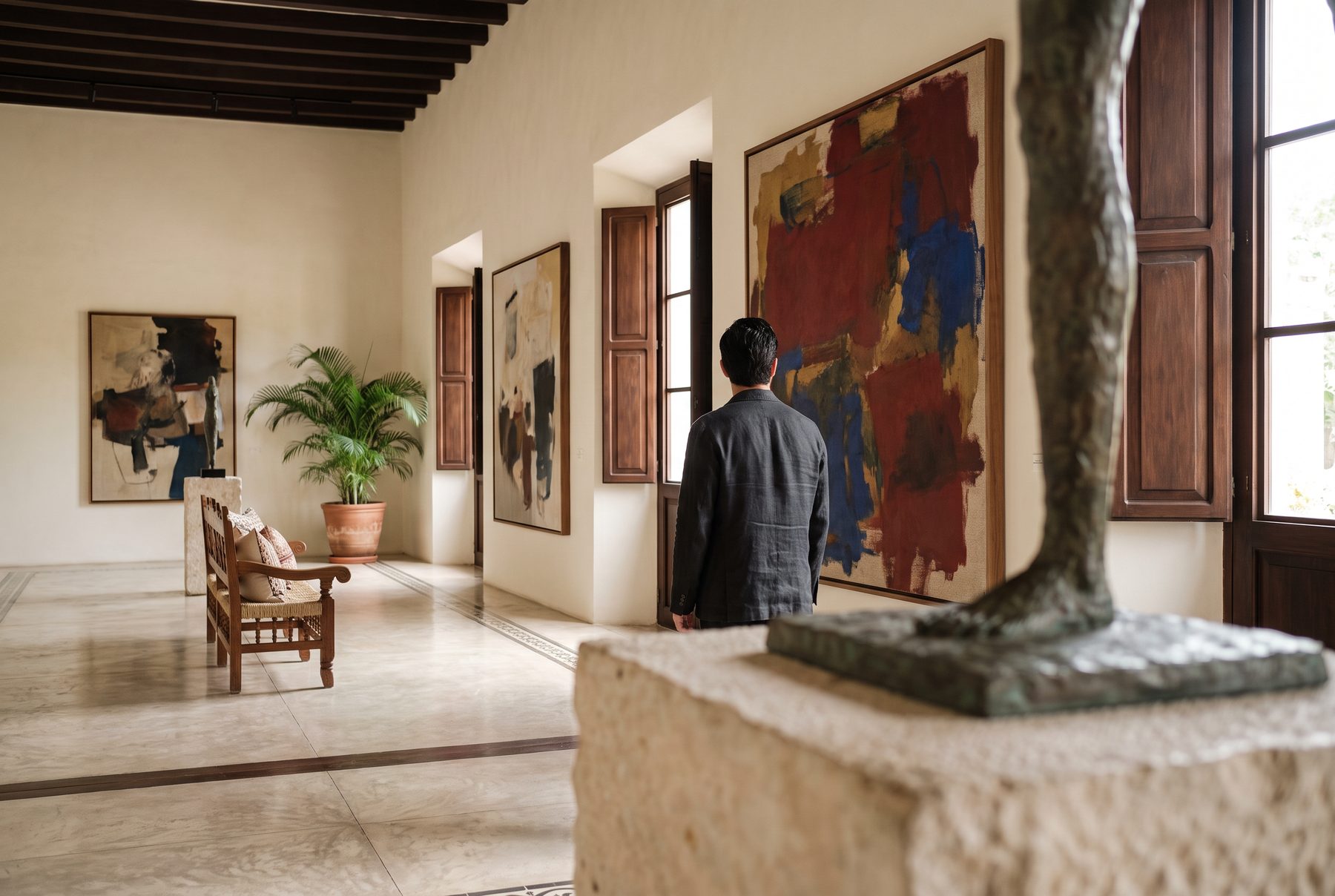 Una persona contempla una pintura abstracta monumental en la galería de una hacienda