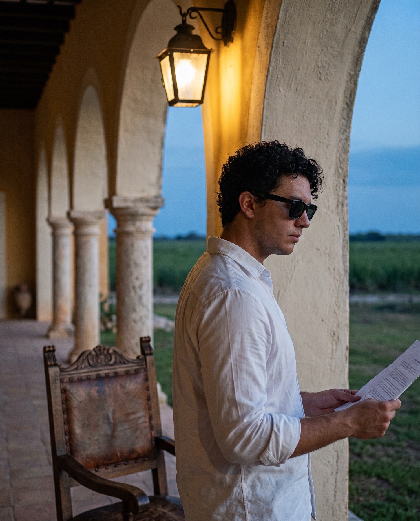 Luis Montaño revisando documentos en el corredor de una hacienda